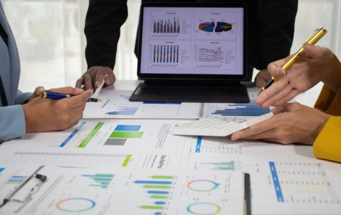 Echipă de analiști economici studiind grafice și date referitoare la stagflație - combinația dintre stagnare economică și inflație