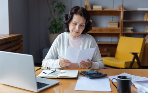 Antreprenoare verificând documente privind TVA intracomunitar la birou