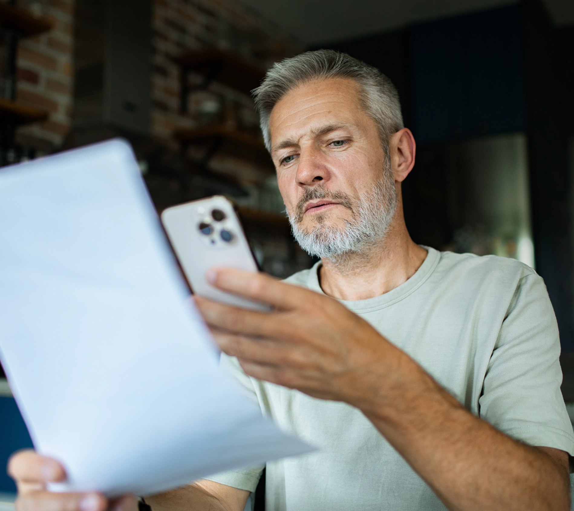 Bărbat de vârstă mijlocie fotografiind o factură cu telefonul, ilustrând procesul simplu de obținere a finanțării prin factoring în 3 pași: încărcare factură, decizie în 1-8 ore și primirea fondurilor în aceeași zi